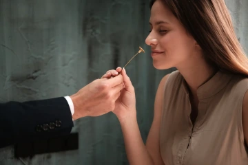 Muž předává krásné ženě zlatou květinu, originální vánoční dárek pro manželku nebo přítelkyni