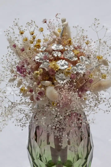 Aranžovaná kytice stříbrných a sušených květin ve skleněné váze