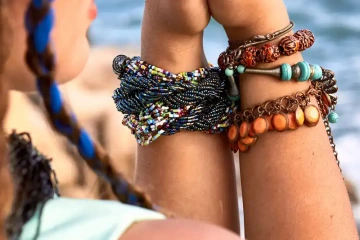 Ruce ženy s boho náramky z korálků na rukách