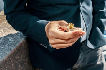 Muž s jednou zlatou chrpou v ruce pro dárek k 1. výročí