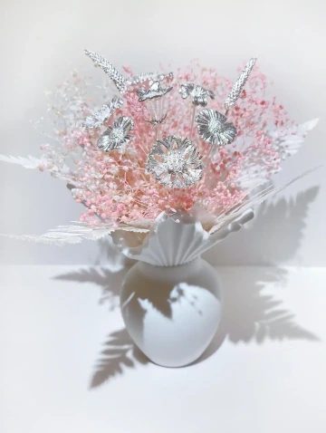 Valentine bouquet of silver and pink flowers in a white vase.
