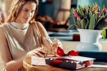 Krásná, mladá žena si rovná darované stříbrné narcisy ve váze, dárek pro dceru