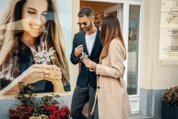 Muž se ženou s kyticí květinových šperků před českým šperkařstvím GIYOU GARDEN v Praze