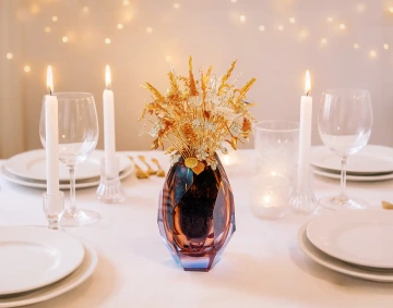 Vánoční kytice zlatých květin na svátečním stole se svíčkami, luxusní vánoční dekorace