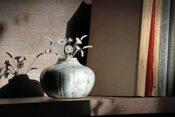 Kytice květin ze stříbra ve váze v knihovně pro originální dekoraci