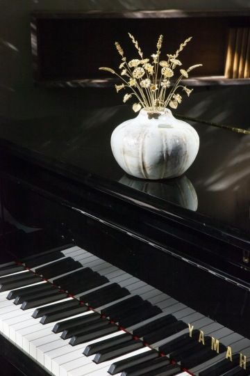 Kytice zlatých květin ve váze položené na klavíru, luxusní dekorace pro luxusní interiéry