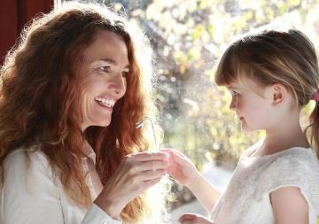 Kid giving a silver flower to her mom