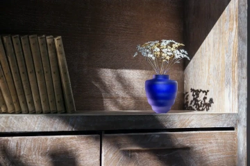 České květiny ze stříbra GIYOU v modré skleněné váze v knihovně