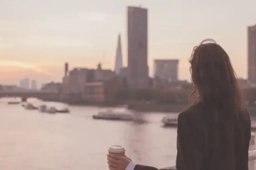 Young woman looking at the river and big city