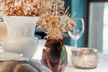 Kytice zlatých květin ve váze na vánočním stole, luxusní vánoční dekorace