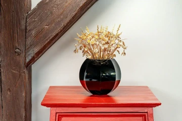 Kytice 50 zlatých květin ve váze na červené komodě, luxusní dárek pro ženu k 50. narozeninám