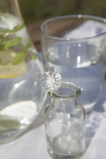 Minimalistická skleněná svatební váza s jednou stříbrnou květinou pro výzdobu svatby