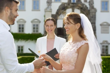 Nevěsta při netradičním svatebním obřadu se zlatými květinami na místo snubních prstýnků