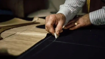 A tailor prepares a tailor-made suit for a man, elegant gift for a man