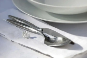 Stříbrná květina položená na svatebním stole