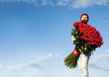 Muž s obří kyticí červených růží