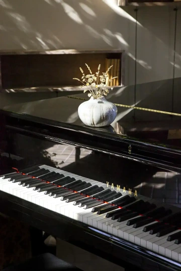 Floral golden jewels in a vase on grand piano, luxury decoration
