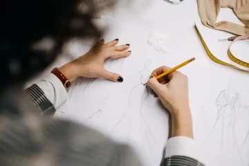 Módní návrhářka kreslí návrh šatů pro ženu k 50. narozeninám