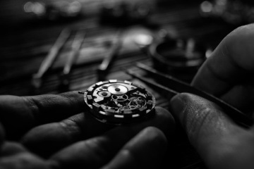 Hands of a watchmaker working on the production of a watch