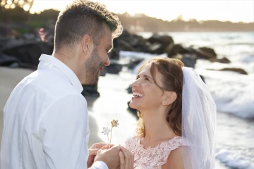 The bride and groom holding two daffodils of white and yellow gold