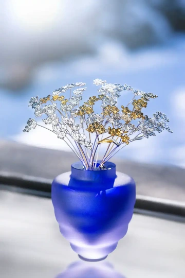 Kytice stříbrných a zlatých květin - pomněnek, v modré váze