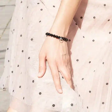 Náhrdelník z bílých a černých korálků na ženě