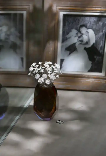 Velké kytice stříbrných květin ve váze se snubními prsteny a svatební fotkou, pro svatební dar