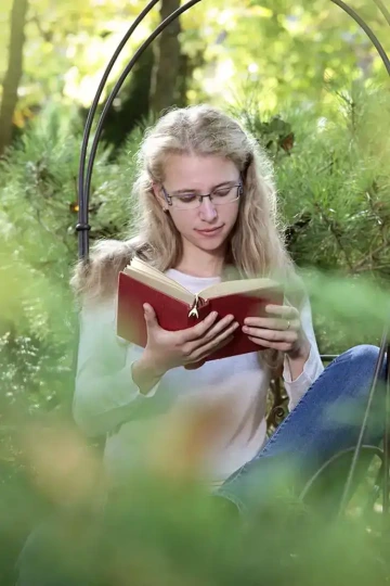 Stříbrná květina, talisman pro štěstí v knížce, kterou čte žena