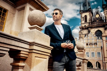 Muž na Staroměstské náměstí držící unikátní české šperkařské květiny, dárek z Prahy