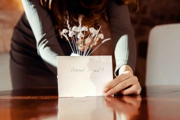 Zásnubní stříbrná kytice ve váze na stole s cedulkou "vezmeš si mě?" při originální žádosti o ruku